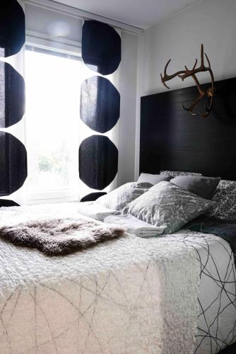 une chambre avec un lit avec une tête de lit noire et une fenêtre dans l'établissement Compact apartment, à Rovaniemi