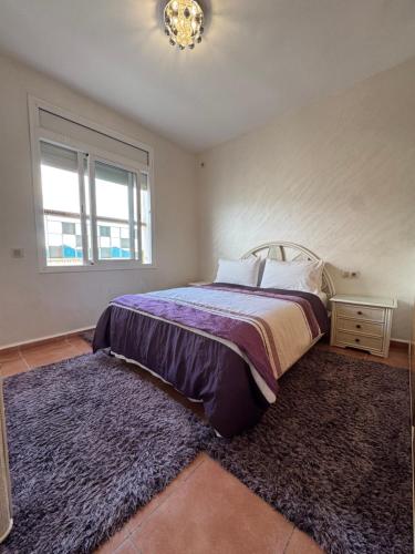 a bedroom with a bed with a rug and a window at Résidence BAB Sebta apartment Ghali in Fnidek