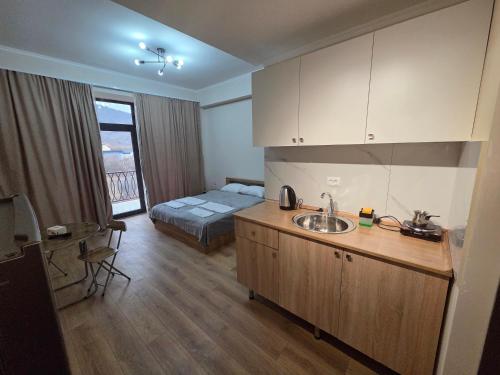 Una cocina con fregadero y una cama en una habitación. en Alvina White Tsaghkadzor, en Tsaghkadzor