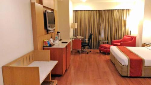 a hotel room with a bed and a desk at Taj Tristar in Hyderabad