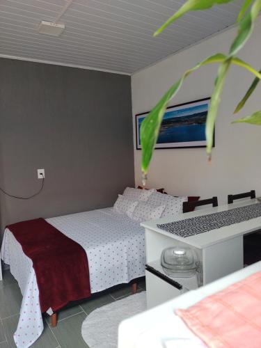 a small bedroom with a bed and a desk at Studio Beira Mar in Imbituba