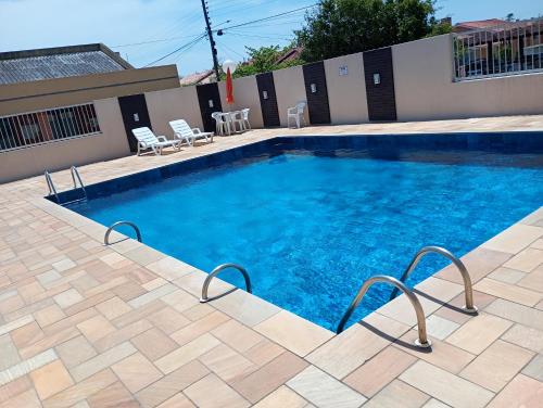 ein großer Swimmingpool mit blauem Wasser in einem Hof in der Unterkunft Capão Novo 111 in Capão da Canoa
