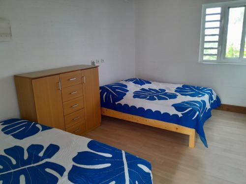 a bedroom with two twin beds and a dresser at Tubuai Mara'ai le spot, Chambre Triple Deluxe Mahu SDB Privée avec piscine in Tubuai