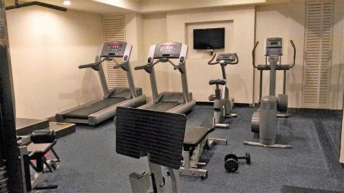 a gym with several tread machines in a room at Taj Tristar in Hyderabad