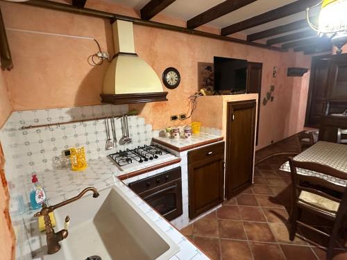 une petite cuisine avec une cuisinière et un évier dans l'établissement Charme Rustico 70 mt from the beach, starlink, à Cefalù