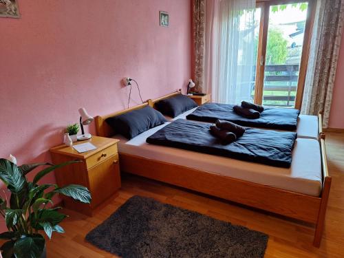 een slaapkamer met een bed met een teddybeer erop bij Pension Haus Marianne in Bad Vöslau