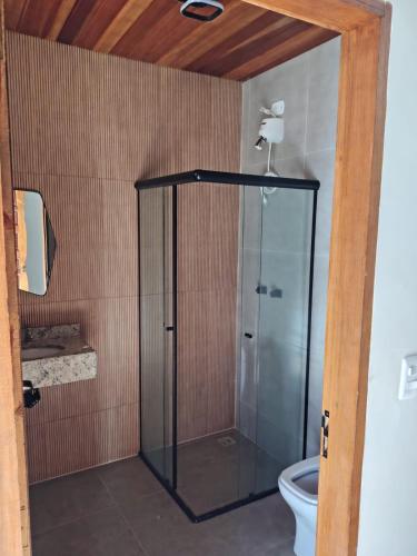 a glass shower in a bathroom with a toilet at Pousada Finca dos Anjos in Passa Quatro