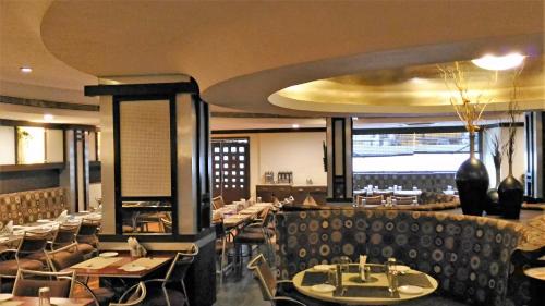 a dining room with tables and chairs in a restaurant at Taj Tristar in Hyderabad