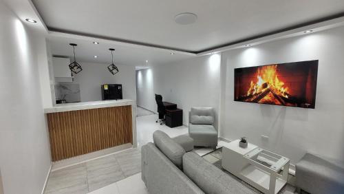 a living room with a couch and a fire painting on the wall at Apartaestudio PA-TY in Cali
