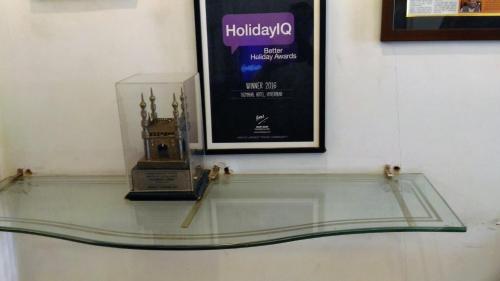 a glass shelf with a clock and a picture at Taj Tristar in Hyderabad