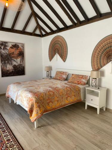 a bedroom with a king sized bed and a night stand at Casita Ricarda in Tazacorte