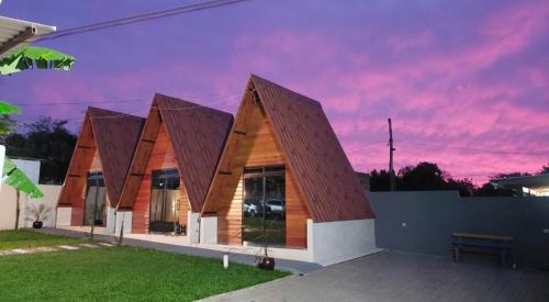 a building with a wooden roof with a sunset at Casa Do Parque in Ijuí