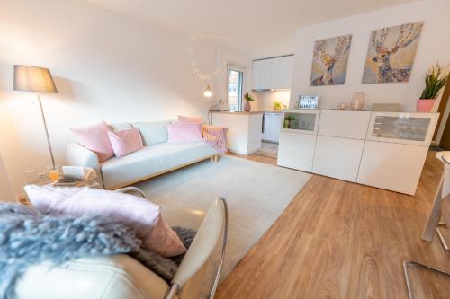 een woonkamer met een bank en een keuken bij Le Belvédère de Loèche in Leukerbad