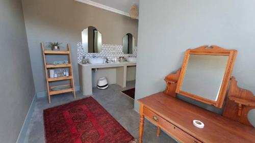 a bathroom with a mirror on a dresser and a sink at Achab Camping Camp site in Usakos