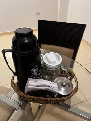 een glazen tafel met daarop een zwarte koffiepot bij Pousada Casa Grande in Arcoverde