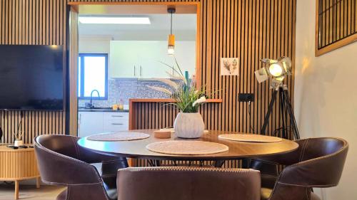 a dining room table with chairs and a vase on it at The North Paradise - Porto Moniz in Porto Moniz