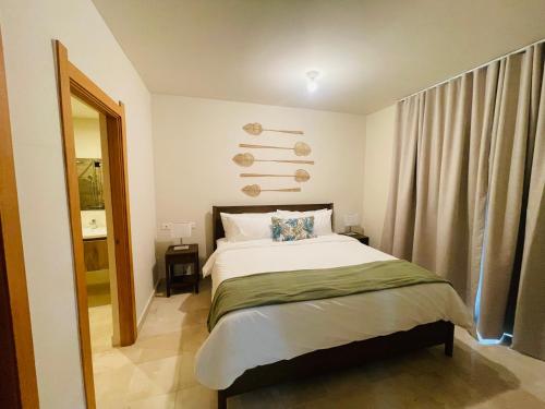 a bedroom with a large bed and a mirror at Garden View Condo 221 Marien Beach Resort Pool Access in Puerto Plata