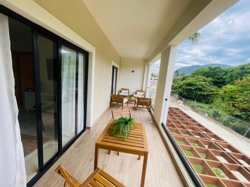 a balcony with a table and chairs on it at Garden View Condo 221 Marien Beach Resort Pool Access in Puerto Plata