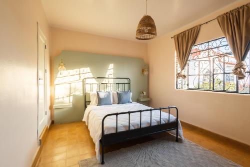 a bedroom with a bed with blue pillows and a window at Casa 906 in Puebla
