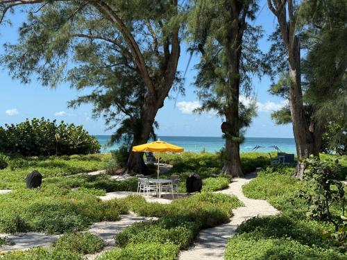 a table with an umbrella on the beach at Bamboo Apartments in Holmes Beach