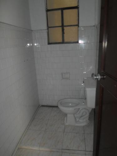a bathroom with a toilet and a window at Gran Hotel El Cedro in Girardot