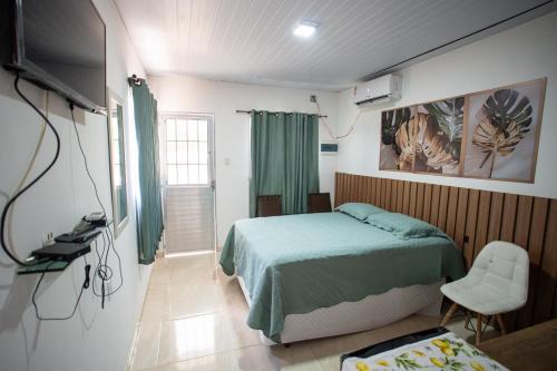 a bedroom with a bed and a tv in it at Ybyra Pousada de Selva in Careiro