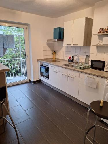 a kitchen with white cabinets and a large window at Big privat Zimmer 5 min walk from Railstation in Koblenz