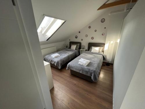 奥西耶克Apartman Stadion的有两张床和一扇窗户的卧室