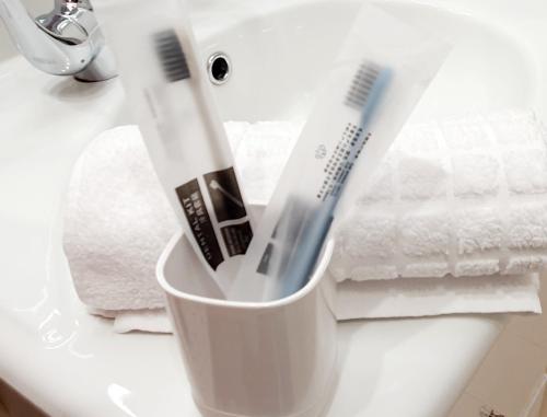 two toothbrushes in a cup on a bathroom counter at Jasmine Home, Aegina City in Aegina Town