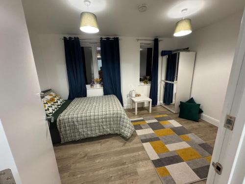 a bedroom with a bed and blue curtains at Brand new house oxford in Oxford