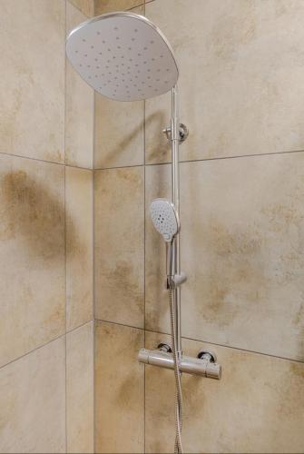a shower with a shower head in a bathroom at Worms City Apartment in Worms