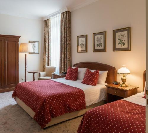 ein Hotelzimmer mit zwei Betten und einem Stuhl in der Unterkunft Sera Apart Ayvalık in Ayvalık