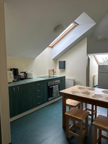 una cocina con armarios verdes y una mesa con sillas en Maidla Hostel, en Maidla