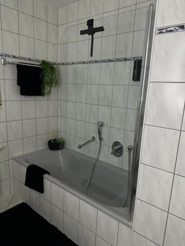a bath tub in a bathroom with a cross on the wall at Ferienwohnung Casa Luma in Altendiez