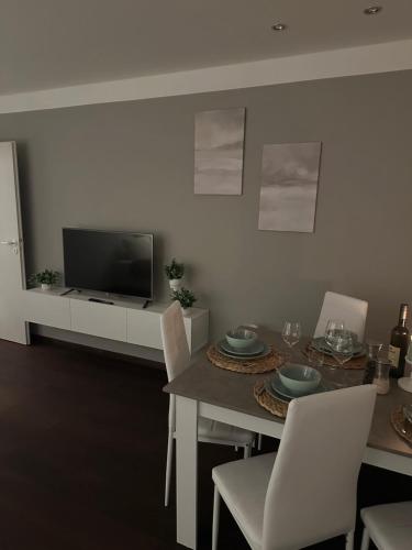 a dining room with a table and a tv at Ferienwohnung Casa Luma in Altendiez