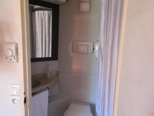 a small bathroom with a toilet and a sink at Premiere Classe Avignon Le Pontet in Le Pontet