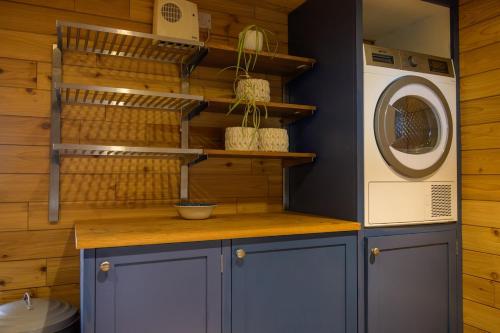 a kitchen with a stove and a washing machine at Sky Garden Cabin - Cabin in the Clouds in Charlton Kings