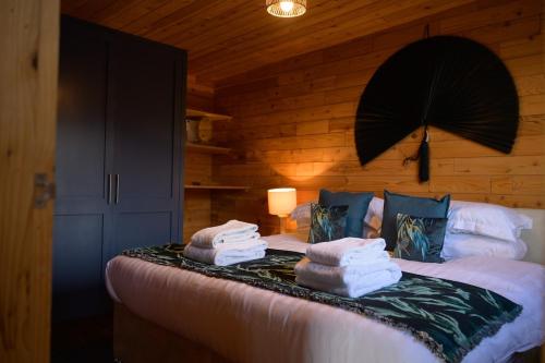 a bedroom with a bed with towels on it at Sky Garden Cabin - Cabin in the Clouds in Charlton Kings
