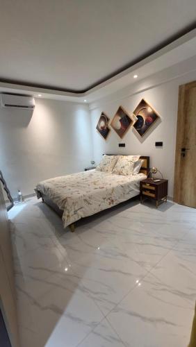 a bedroom with a bed with paintings on the wall at F3 2 Chambres Piscine Residence Point E in Dakar