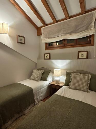a bedroom with two beds and a ceiling at Casa ARRUIZ in Riaza