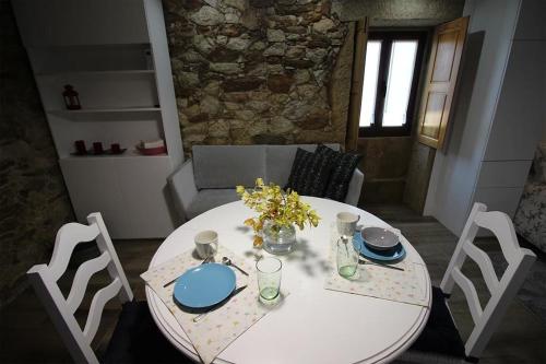 a dining room table with a white table and chairs at Casinha Pousafoles in Arouca