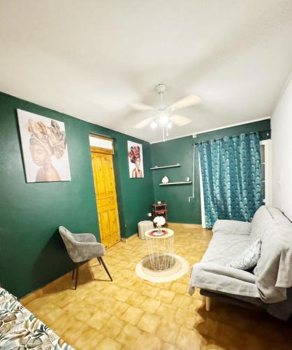 una sala de estar con un sofá y una mesa en L'herbe à pic., en Les Abymes