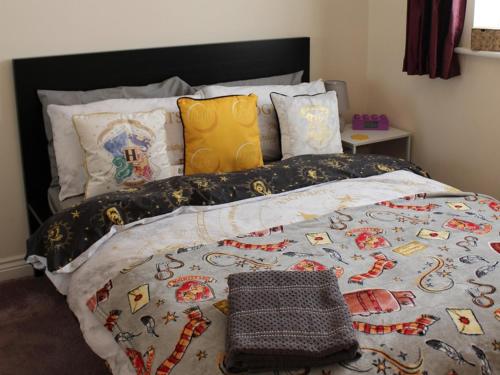 ein Bett mit einer Bettdecke und Kissen darauf in der Unterkunft Royal Brick Home - Sleeps 5 to 6 - No ULEZ - Tube Nearby - Free Parking - Lego Themed in Slough