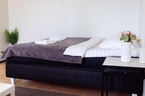 a bedroom with a bed and a table with flowers at Railway&bus station studio, parking in Oulu