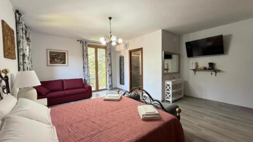 ein Schlafzimmer mit einem roten Bett und einem roten Sofa in der Unterkunft Villa Casavecchia Caselli in Dicomano