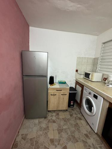 una cocina con nevera y lavadora en L'herbe à pic., en Les Abymes