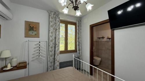 ein Schlafzimmer mit einem Bett, einem Fenster und einer Treppe in der Unterkunft Charming Guest Room in Villa Casavecchia with City, Garden, and Mountain Views in Dicomano