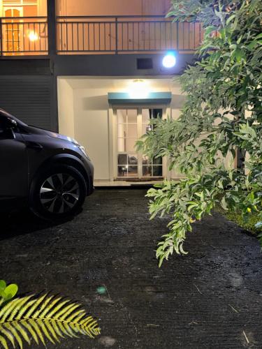 un coche aparcado delante de un edificio en L'herbe à pic., en Les Abymes