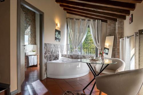 a bathroom with a tub and a window and a table at Villa D&D in Parma