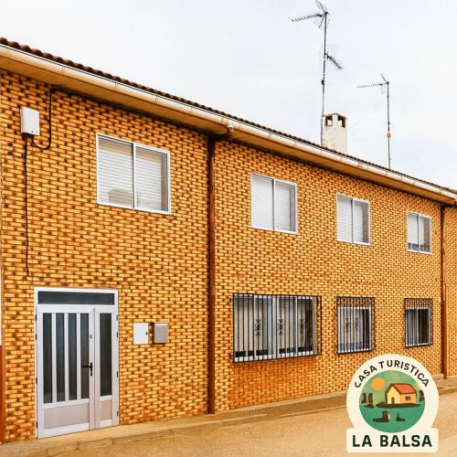 a brick building with a white door in front of it at La Balsa in Matalebreras